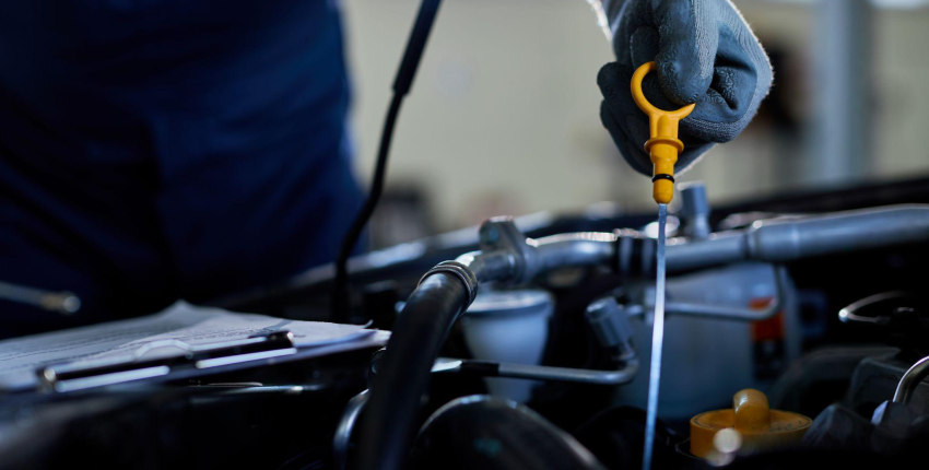 Mechanic checking engine oil level from dipstick